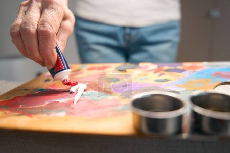 Foto de Mujer creativa mezclando pinturas en una paleta de arte, dibujando su hobby - Imagen libre de derechos