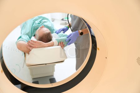 Foto de Hombre adulto acostado con las manos arriba en la cámara de la máquina de resonancia magnética en la clínica - Imagen libre de derechos