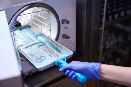 Foto recortada el proceso de esterilización de instrumentos médicos en un autoclave