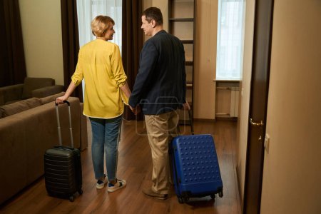 Foto de Pareja con maletas de viaje check-in en una habitación de hotel, la pareja toma de la mano - Imagen libre de derechos