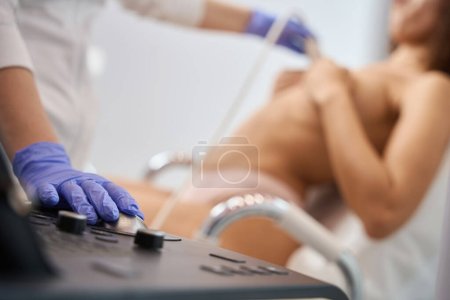 Foto de Primer plano del aparato para la realización de ultrasonido de las glándulas mamarias, paciente mujer en consultorio médico - Imagen libre de derechos