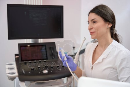 Téléchargez les photos : Docteur Lady est assis près de la machine et montre au patient le résultat de l'échographie - en image libre de droit