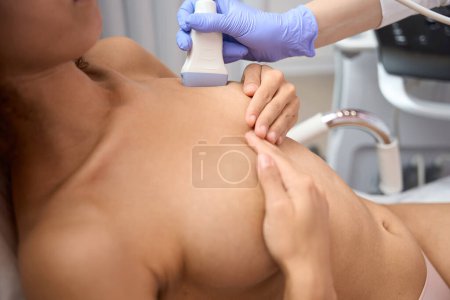Téléchargez les photos : Le docteur fait une échographie des glandes mammaires d'une jeune femme. - en image libre de droit