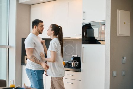 Téléchargez les photos : Les jeunes conjoints trient émotionnellement les choses dans la cuisine, les gars en vêtements de maison - en image libre de droit