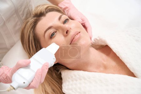 Téléchargez les photos : Le patient subit une procédure pour niveler la surface de la peau du visage avec un laser CO2, à l'aide d'un dispositif moderne - en image libre de droit