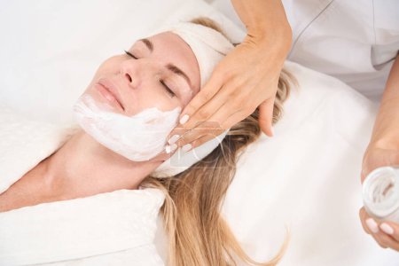 Foto de Mujer en una sesión de infusión dérmica en una clínica de medicina estética, cosmetólogo aplica suero especial a los clientes la piel de la cara - Imagen libre de derechos