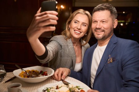 Foto de Mujer feliz tomando selfie con el novio de la cafetería, principio de las relaciones románticas - Imagen libre de derechos