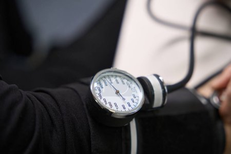 Foto de Se comprueba la presión arterial de la persona con un aparato especial, un especialista utiliza un tonómetro y un estetoscopio - Imagen libre de derechos