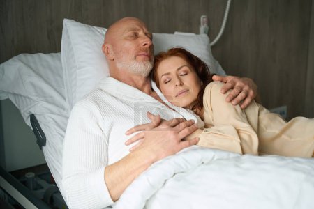 Foto de Hombre guapo y mujer bonita en ropa elegante durmiendo en abrazo en el interior - Imagen libre de derechos