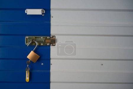 Foto de Cerradura abierta con llave está colgando en el cerrojo de las puertas de una caja de almacenamiento en un almacén - Imagen libre de derechos