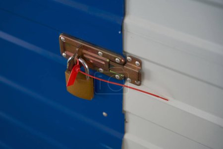 Téléchargez les photos : Fermer la serrure est accroché sur le pêne dormant des portes d'une boîte de rangement dans un entrepôt - en image libre de droit