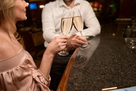 Photo for Cropped photo of handsome man and charming lady clinking glasses while having romantic date in the restaurant - Royalty Free Image