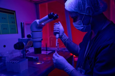 Labortechniker für Reproduktionstechnologie führt Tests mit Blutproben durch, pipettiert reaktiv im Reagenzglas und beobachtet die Reaktion
