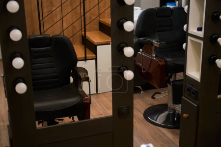 Photo for Modern barber workplace in a barbershop with a modern minimalist design, mirrors, leather chairs, excellent lighting - Royalty Free Image