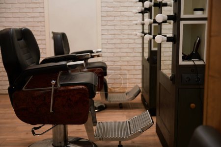 Téléchargez les photos : Salon de coiffure avec un design minimaliste moderne, confortables chaises de coiffure, miroirs - en image libre de droit