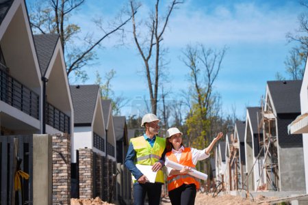 Photo for Main construction worker showing construction site with almost builded houses to housing developer, discussing building progress - Royalty Free Image