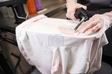 Photo for Close-up dry-cleaning worker removing stains from delicate fabric using professional steam-air gun - Royalty Free Image