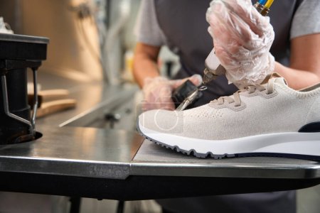 Téléchargez les photos : Nettoyage professionnel des chaussures avec pistolet et pistolet à vapeur de nettoyage par solvant et par taches, service de nettoyage à sec - en image libre de droit