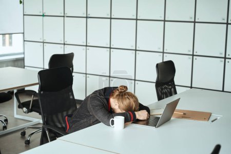 Photo for Tired guy dozed off at the laptop at the workplace, the room is light and comfortable - Royalty Free Image
