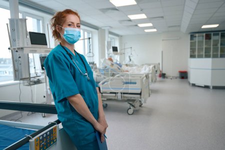 General doctor wearing the medical face mask and standing in the reanimation ward