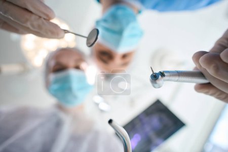 Photo for Surgeon dentist with an assistant at the workplace in the operating room, professionals have special tools - Royalty Free Image