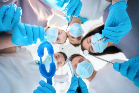 Photo for Team of dentists of five people with dental instruments in their hands, doctors in medical uniforms - Royalty Free Image