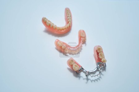 Three variants of modern dentures lie on the table, they are made of environmentally friendly materials