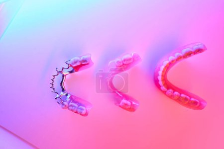 Photo for Three variants of dentures lie on the table, they are processed by an infrared lamp - Royalty Free Image