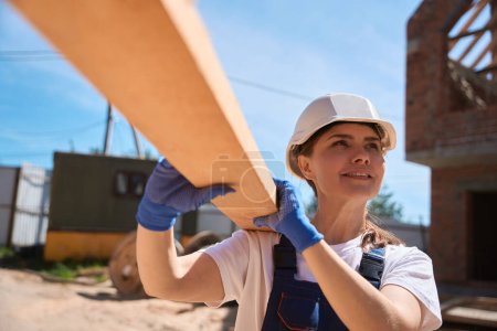 Foto de Carpintero mujer preparando vigas y entregando su techo para la construcción de marcos de madera, controlando el proceso de construcción - Imagen libre de derechos