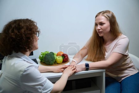 Young woman in a fitness clinic on a consultation with a nutritionist, a specialist supports a client