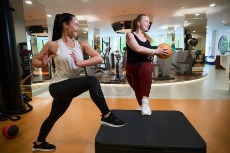 Foto de Entrenador de fitness joven que trabaja con el cliente en el gimnasio de la clínica de fitness, mujer usando pelota - Imagen libre de derechos