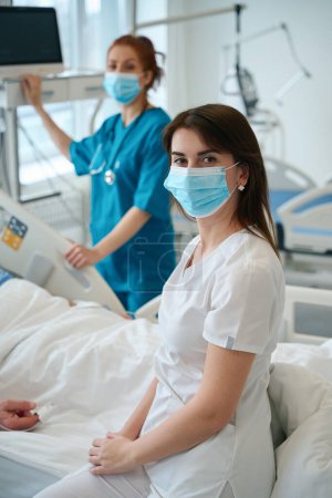 Photo for Female medics near patients bed who lying in the resuscitation in hospital - Royalty Free Image