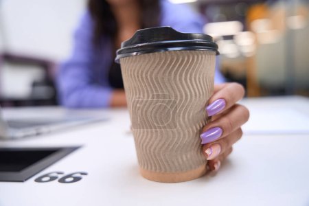 Photo for Cropped view on hand of female with beautiful manicure holding cup of coffee indoors - Royalty Free Image