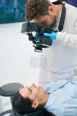Photo for Dental technician using professional equipment to make x-ray image of client teeth, aesthetic dentistry, implantology - Royalty Free Image