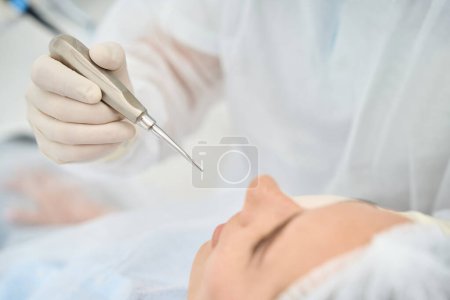 Téléchargez les photos : Femme à un rendez-vous chez le médecin dans une clinique dentaire, le dentiste utilise des outils spéciaux - en image libre de droit