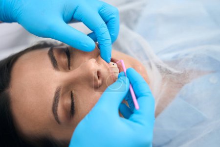 Téléchargez les photos : Femme brune au rendez-vous chez le dentiste, le médecin utilise des outils spéciaux et des gants de protection pour le travail - en image libre de droit