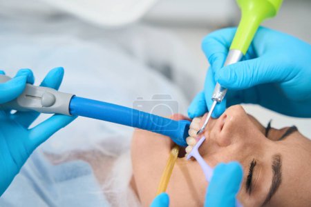 Photo for Patient at the doctors appointment is located in the dental chair, the doctor uses special tools for work - Royalty Free Image