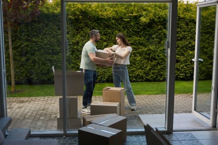 Téléchargez les photos : Beau homme tenant boîte en carton tandis que sa petite amie le regardant flirter à l'extérieur - en image libre de droit