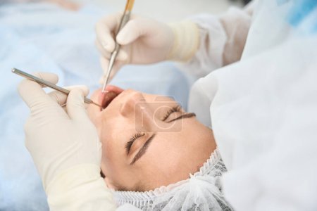 Téléchargez les photos : Femme dans une clinique chez un dentiste, le médecin nettoie le canal dentaire - en image libre de droit