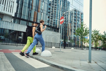 Foto de Pareja joven, hablando, camina a lo largo de un paso peatonal, junto a una señal de tráfico - Imagen libre de derechos