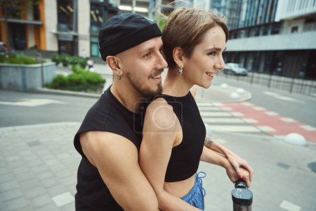 Photo for Cheerful male with a girlfriend ride around the city on a scooter, they move along the sidewalk - Royalty Free Image