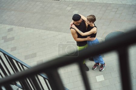 Foto de Pareja feliz está de pie, abrazando, en la acera, los chicos están en un paseo por la ciudad - Imagen libre de derechos