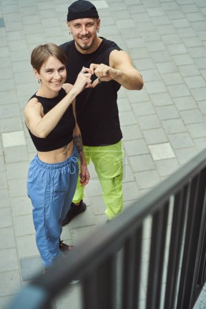 Téléchargez les photos : Happy couple montre un cœur avec leurs mains, les gars sur une promenade en ville - en image libre de droit
