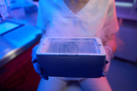 Photo for Female embryologist holding a tank with liquid nitrogen for cryopreservation of biological material - Royalty Free Image