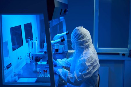 Foto de Embriólogo en uniforme estéril utiliza un conjunto de micromanipuladores, también utiliza un microscopio potente - Imagen libre de derechos