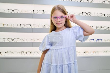 Photo for Confident young lady trying on new pair of glasses in optical store - Royalty Free Image