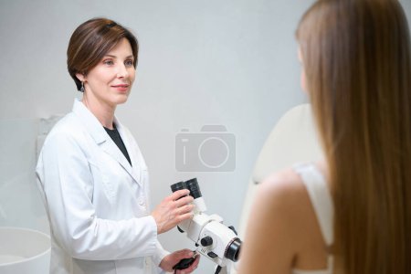 Foto de La doctora usa un microscopio ginecológico en su trabajo, una joven en una cita con un genicólogo - Imagen libre de derechos