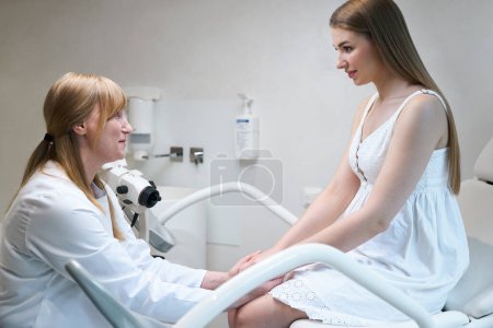 Foto de Mujer joven es consultada por un ginecólogo en un centro médico, el médico se comunica con el paciente - Imagen libre de derechos