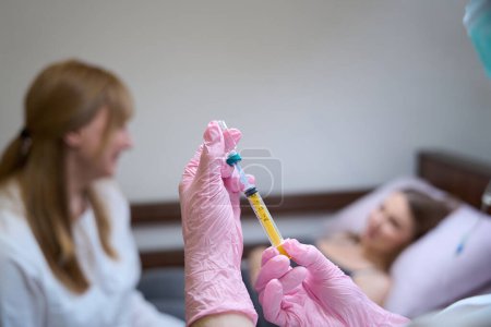 Foto de El médico se comunica con el paciente en la habitación del hospital, la enfermera prepara la inyección - Imagen libre de derechos