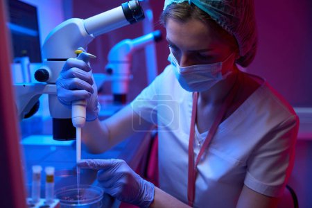 Embryologin in einem Kryolab arbeitet mit einem Biomaterial, sie verwendet einen speziellen Manipulator